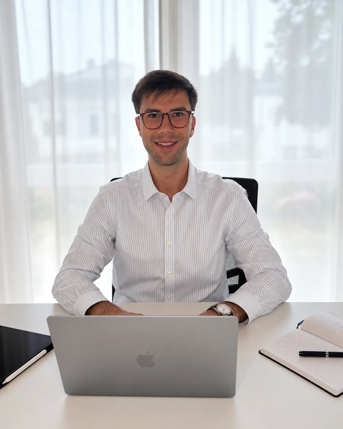 Felix Donder am Schreibtisch mit Laptop, lächelt in die Kamera